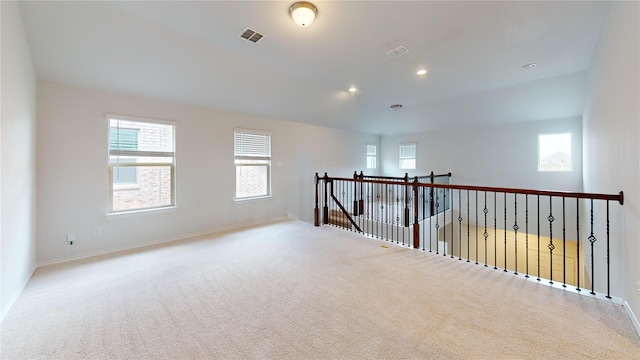 spare room featuring light carpet