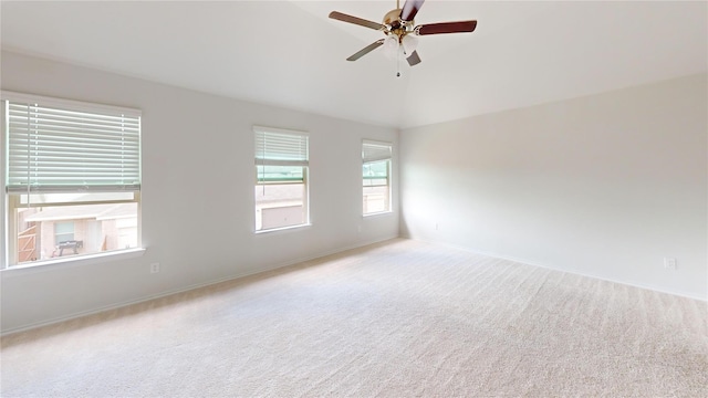 carpeted spare room featuring ceiling fan and lofted ceiling