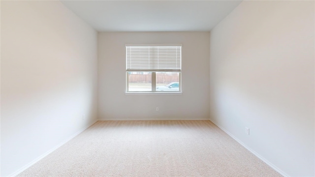 spare room featuring light colored carpet