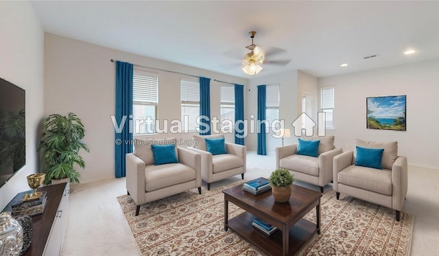 carpeted living room with ceiling fan and a healthy amount of sunlight