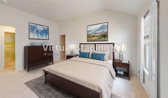 bedroom featuring light carpet, ensuite bathroom, and vaulted ceiling