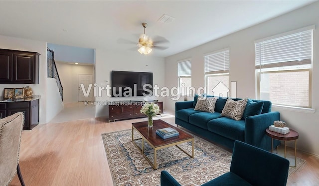 living room featuring ceiling fan and light hardwood / wood-style flooring