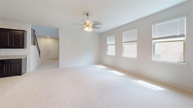 unfurnished room with light colored carpet and ceiling fan