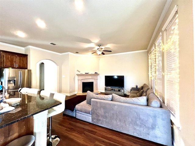 living room with ceiling fan, dark hardwood / wood-style flooring, and ornamental molding