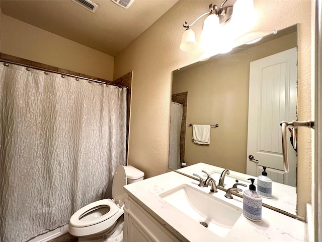 bathroom featuring vanity, toilet, and curtained shower