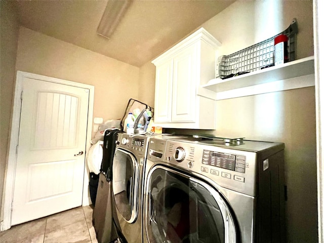 laundry area with washer and dryer, light tile patterned flooring, and cabinets