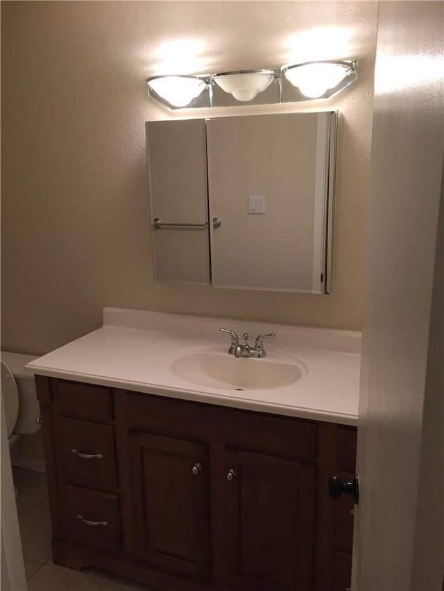 bathroom featuring tile patterned floors, vanity, and toilet