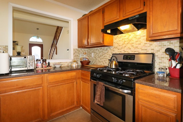 kitchen with decorative backsplash, tile patterned flooring, decorative light fixtures, and stainless steel range with gas cooktop