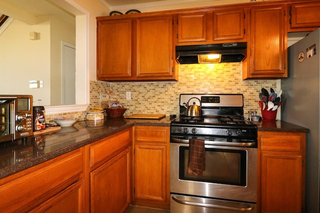 kitchen with dark stone counters, appliances with stainless steel finishes, and tasteful backsplash