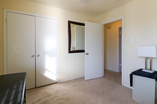 carpeted bedroom with ceiling fan and a closet