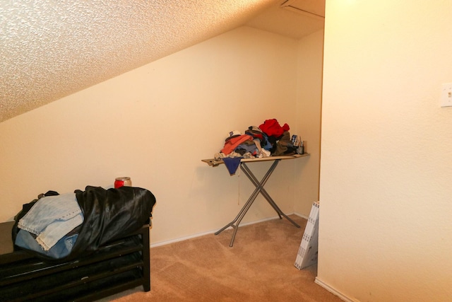 sitting room with carpet floors, a textured ceiling, and vaulted ceiling