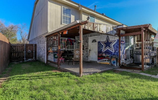 rear view of property with a patio and a lawn