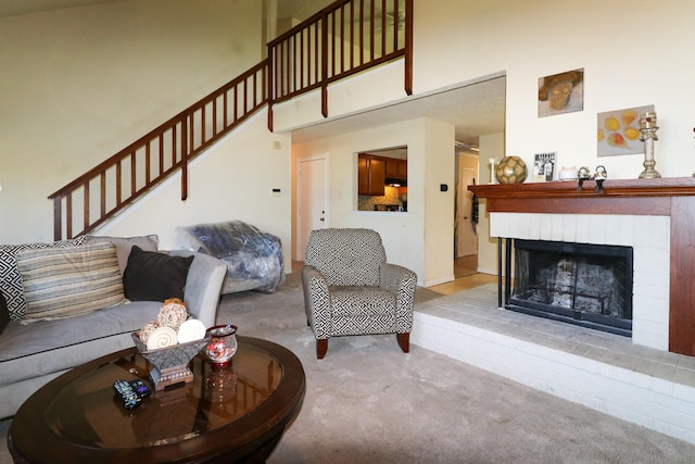 living room featuring light carpet, a towering ceiling, and a brick fireplace