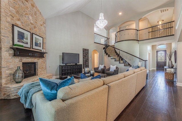 living room featuring high vaulted ceiling, dark hardwood / wood-style floors, and a fireplace