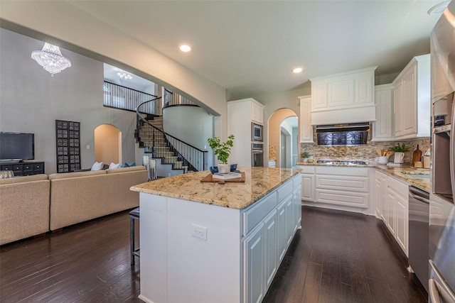 kitchen featuring dark hardwood / wood-style flooring, a center island, white cabinets, and appliances with stainless steel finishes