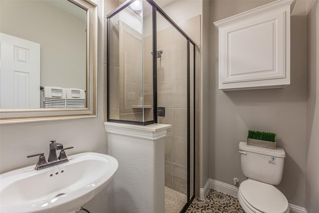 bathroom with tile patterned flooring, toilet, a shower with shower door, and sink