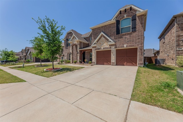 view of front of property featuring a garage, central air condition unit, and a front yard