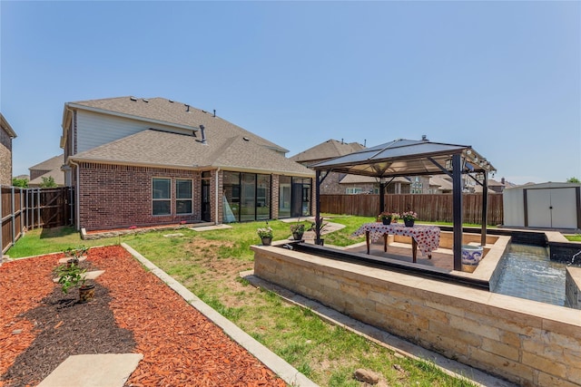 back of house featuring a gazebo, a yard, a patio area, and a shed