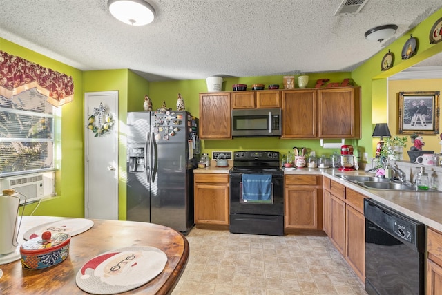 kitchen with cooling unit, sink, a textured ceiling, and black appliances