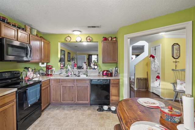 kitchen featuring crown molding, sink, black appliances, and a textured ceiling