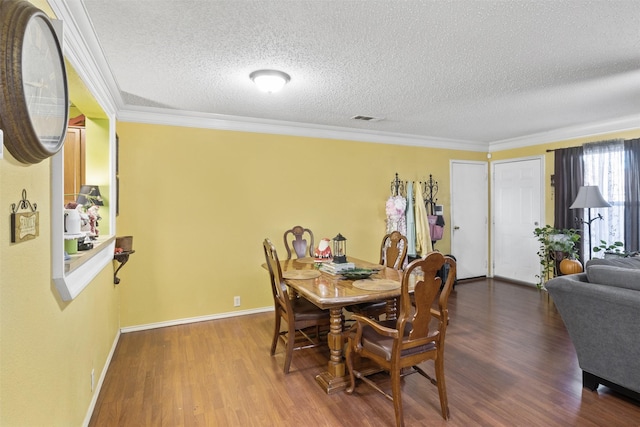 dining space with hardwood / wood-style floors, crown molding, and a textured ceiling