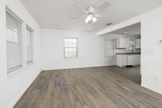 unfurnished living room featuring ceiling fan and dark hardwood / wood-style flooring