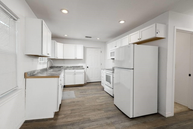 kitchen featuring white cabinetry, white appliances, sink, and light hardwood / wood-style flooring