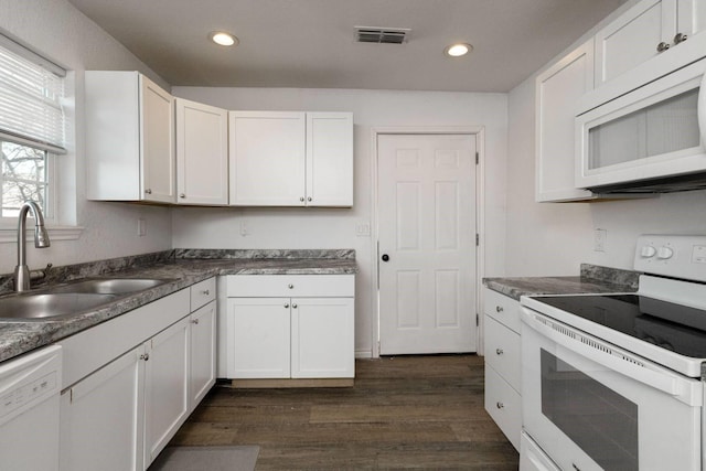 kitchen featuring white appliances, white cabinetry, dark wood-type flooring, and sink