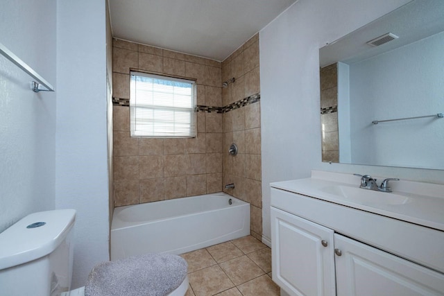 full bathroom with tile patterned flooring, vanity, tiled shower / bath combo, and toilet