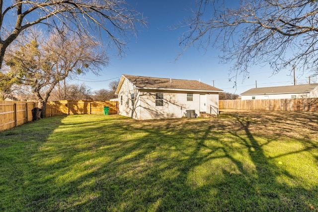 back of house featuring central AC unit and a lawn