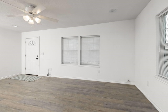 empty room with ceiling fan and dark wood-type flooring