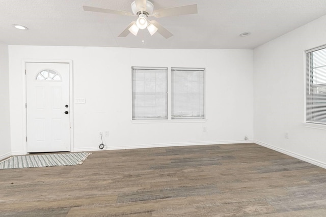 foyer entrance featuring a textured ceiling, ceiling fan, and dark hardwood / wood-style floors