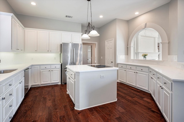 kitchen featuring decorative light fixtures, a center island, decorative backsplash, appliances with stainless steel finishes, and white cabinets