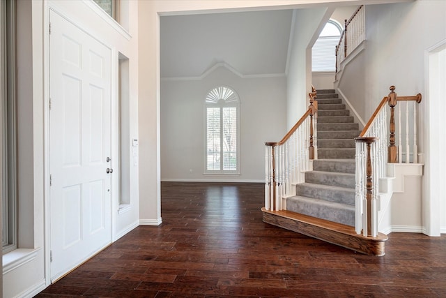 entryway with dark hardwood / wood-style floors and ornamental molding