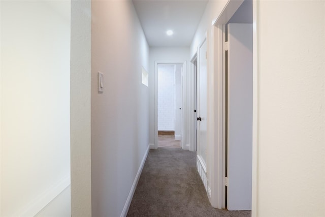 hallway with dark colored carpet