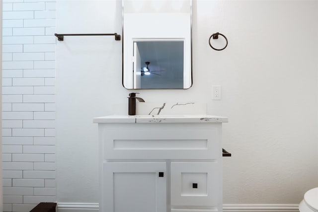 bathroom with walk in shower, vanity, toilet, and ceiling fan