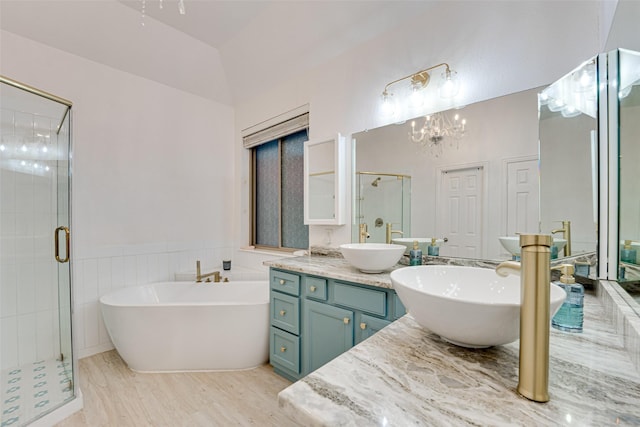 bathroom with shower with separate bathtub, vanity, lofted ceiling, and a notable chandelier