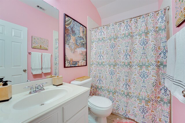 bathroom with vanity, toilet, and vaulted ceiling