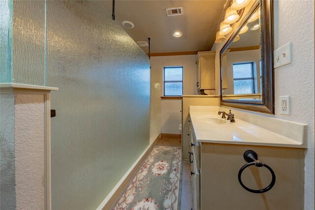 bathroom with vanity, plenty of natural light, and crown molding