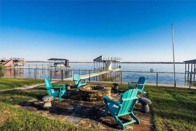 view of patio featuring a fire pit, a water view, and a dock