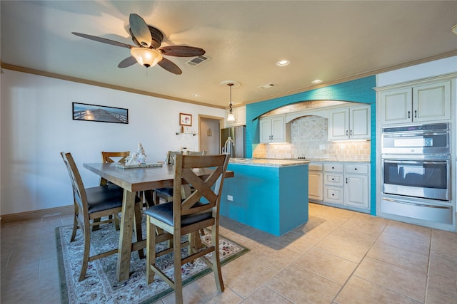 dining area with ceiling fan, sink, light tile patterned floors, and crown molding