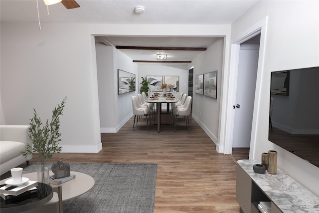 living room featuring ceiling fan, beam ceiling, and wood-type flooring