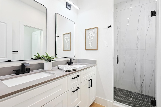 bathroom featuring a shower with door and vanity