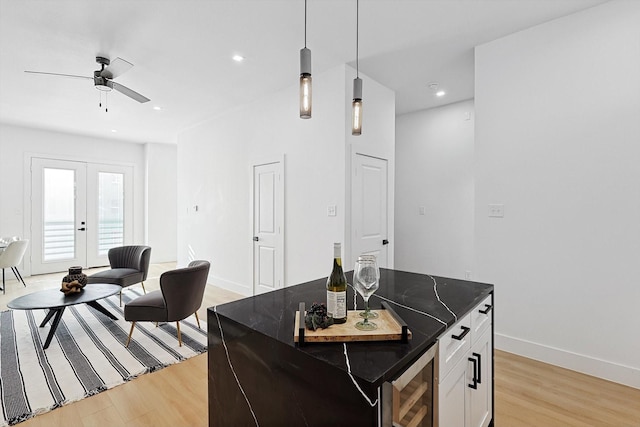 kitchen featuring french doors, a kitchen island, pendant lighting, light hardwood / wood-style floors, and white cabinets