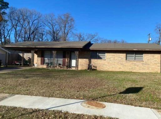 ranch-style house with a front lawn and a carport