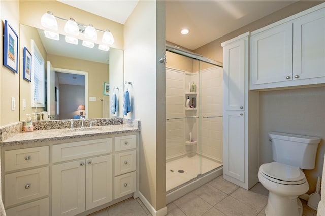 bathroom with tile patterned floors, vanity, toilet, and an enclosed shower