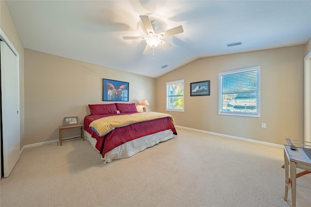 carpeted bedroom featuring a ceiling fan, visible vents, lofted ceiling, and baseboards