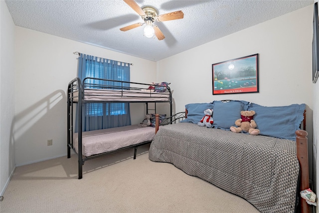 carpeted bedroom featuring ceiling fan and a textured ceiling