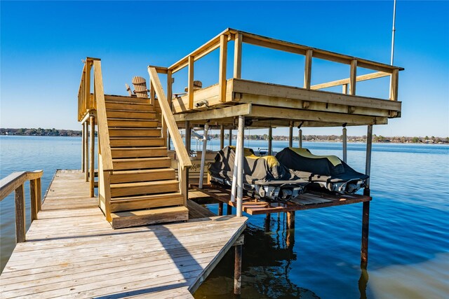 view of dock with boat lift and a water view