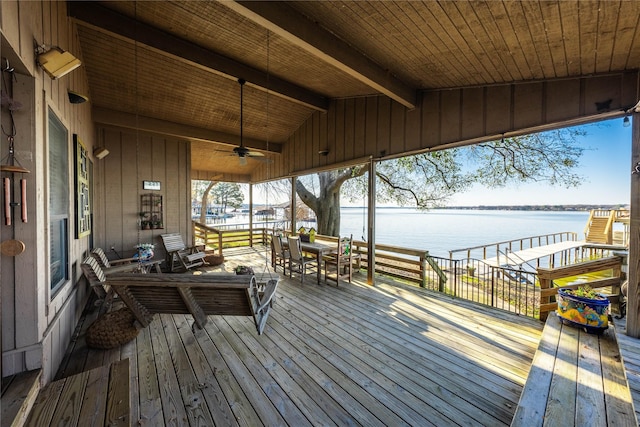 wooden deck with ceiling fan and a water view